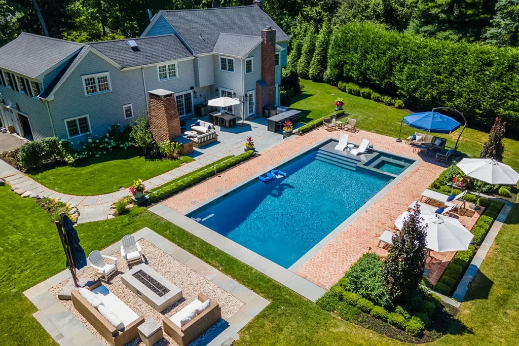 Aerial view of a complete Long Island backyard transformation with pool, patio and outdoor kitchen