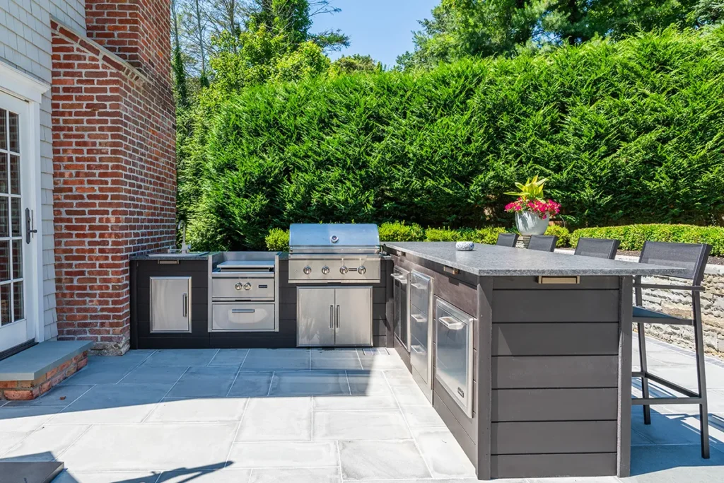 Outdoor kitchen bar with umbrella on a stone patio, detail view