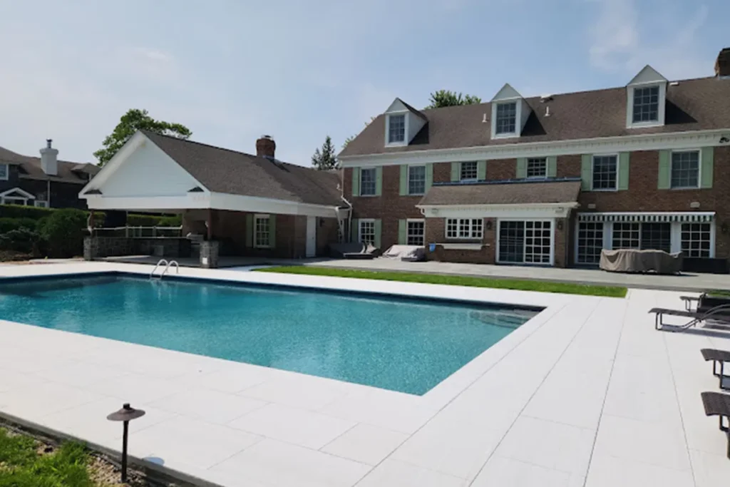 Pool with white coping and light paver deck