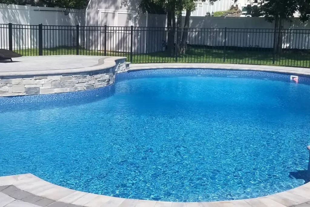 Renovated pool with light gray paver deck and lounge seating